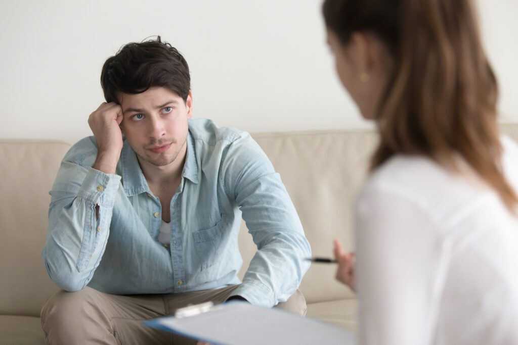 Mental Health - Serious guy listening to female psychologist, diagnosis or doctors instructions